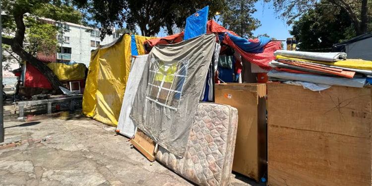 Migrantes reconstruyen campamento en la Venustiano Carranza tras desalojo
